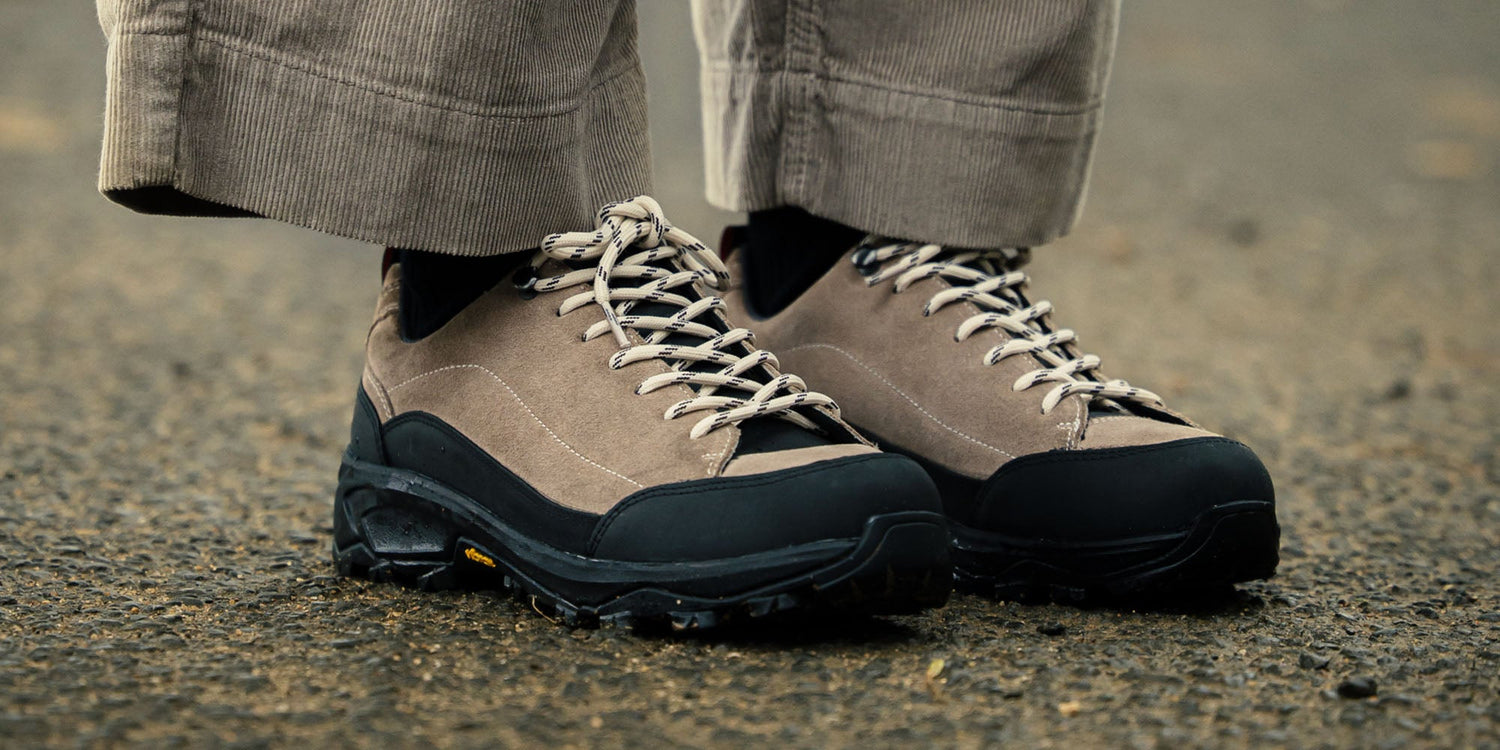 A woman sat on a rug wearing the Calder Anthracite, gum soled, derby shoes.